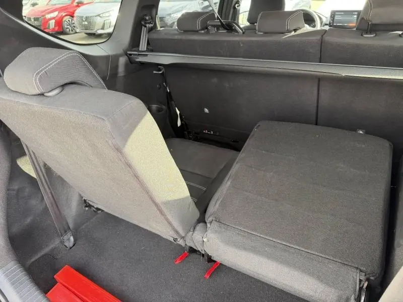 Vue intérieure du coffre du Dacia Jogger 2025 montrant les sièges arrière rabattus et relevés en tissu noir.