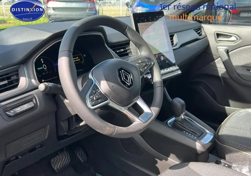 Intérieur Renault Captur 2025 vu côté conducteur, volant multifonction et écran tactile vertical noir.