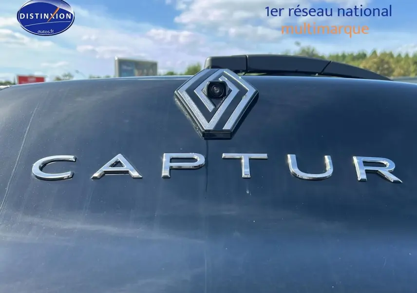 Gros plan sur le logo Renault et l’inscription Captur en lettres chromées sur la malle arrière noire étoile.