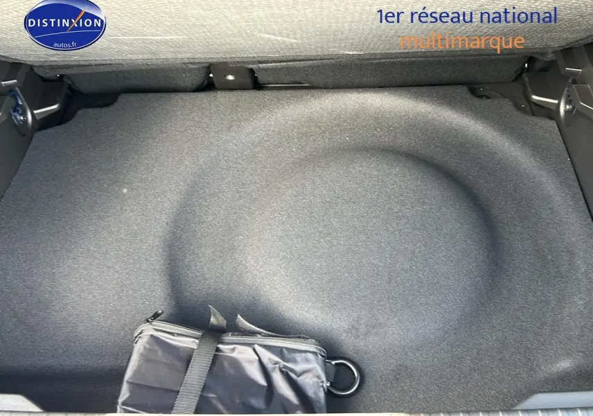 Coffre ouvert du Renault Captur noir Étoile, vue plongeante sur le rangement sous plancher avec trousse noire.