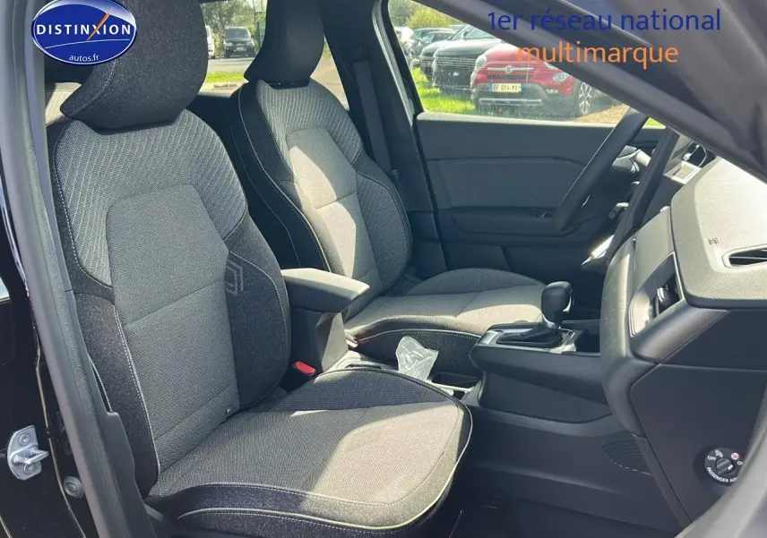Vue intérieure côté conducteur du Renault Captur 1.6 e-tech hybride 2025, sièges tissu gris et console centrale noire.