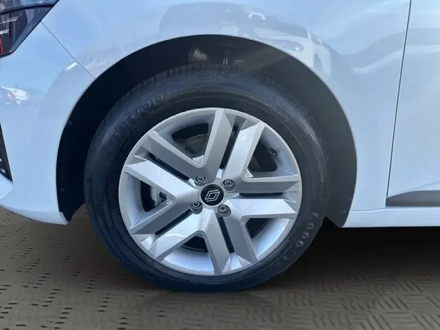 Gros plan sur la roue avant gauche de la Renault Clio blanche 2025 avec jante alliage et logo central Renault.