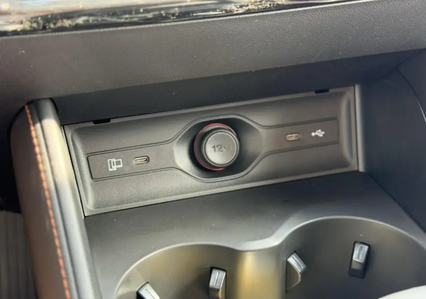 Gros plan sur la console centrale noire du MG Motor EHS 1.5 Hybrid+ 224 Luxury avec prise 12V et ports USB-C.