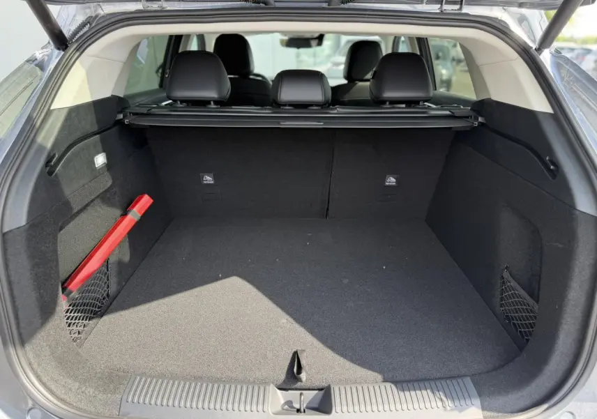 Coffre ouvert vu de l'arrière d'un MG MOTOR EHS gris, montrant un espace de chargement propre et bien agencé.
