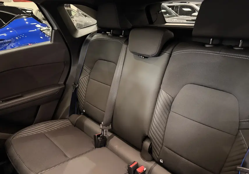 Vue intérieure des sièges arrière en tissu noir avec surpiqûres bleues du Renault Symbioz E-Tech full hybrid 2026.