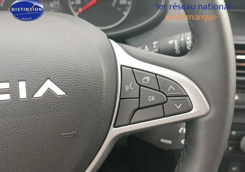 Gros plan sur les commandes multifonctions du volant noir de la Dacia Sandero 2025, côté droit.