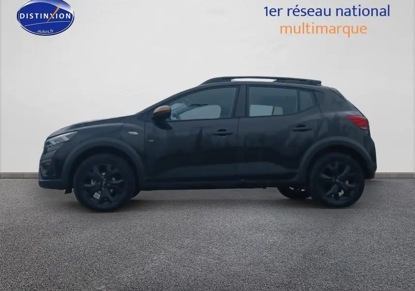Profil droit d'une Dacia Sandero Stepway noire 2025 avec barres de toit et jantes noires.
