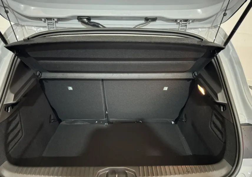 Coffre ouvert de la Renault Clio gris clair vue de l’arrière, montrant l’espace de chargement vide et la tablette de séparation.