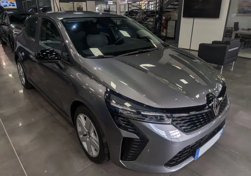 Renault Clio V TCe 90 Evolution gris schiste vue 3/4 avant en showroom avec phares LED et calandre noire.