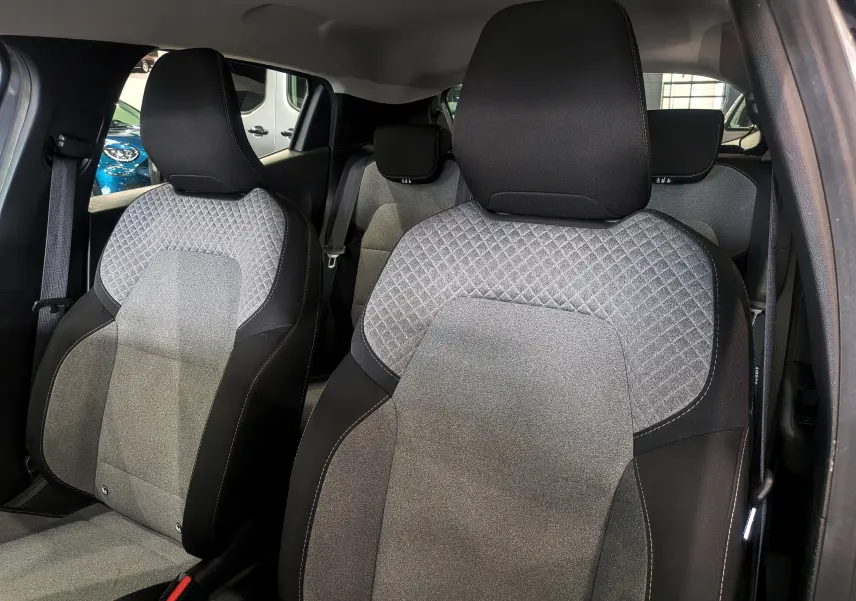 Vue intérieure des sièges avant en tissu gris clair et noir de la Renault Clio V TCe 90 CH Evolution 2024.