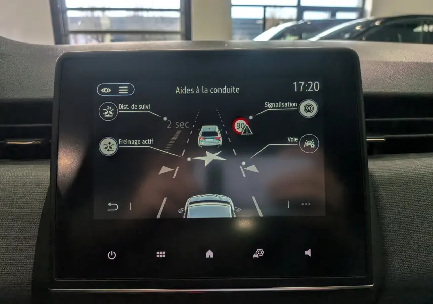 Écran central de la Renault Clio V gris schiste montrant les aides à la conduite avec alertes de distance et signalisation.