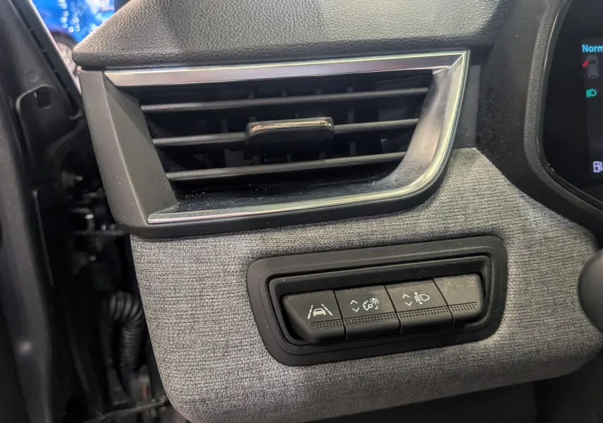 Détail du tableau de bord de la Renault Clio V TCe 90 Evolution 2024, montrant les commandes d'assistance et la sortie d'air.