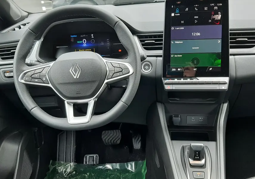 Vue intérieure frontale du tableau de bord du Renault Captur E-Tech Full Hybrid 160ch avec volant multifonction et écran tactile vertical.