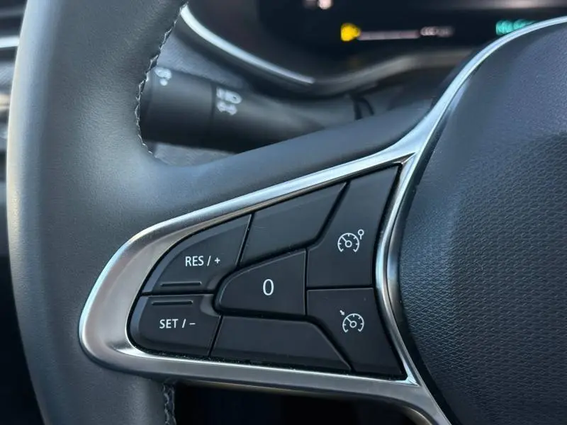 Détail des commandes au volant côté gauche de la Renault Clio 2025, boutons de régulateur de vitesse visibles.