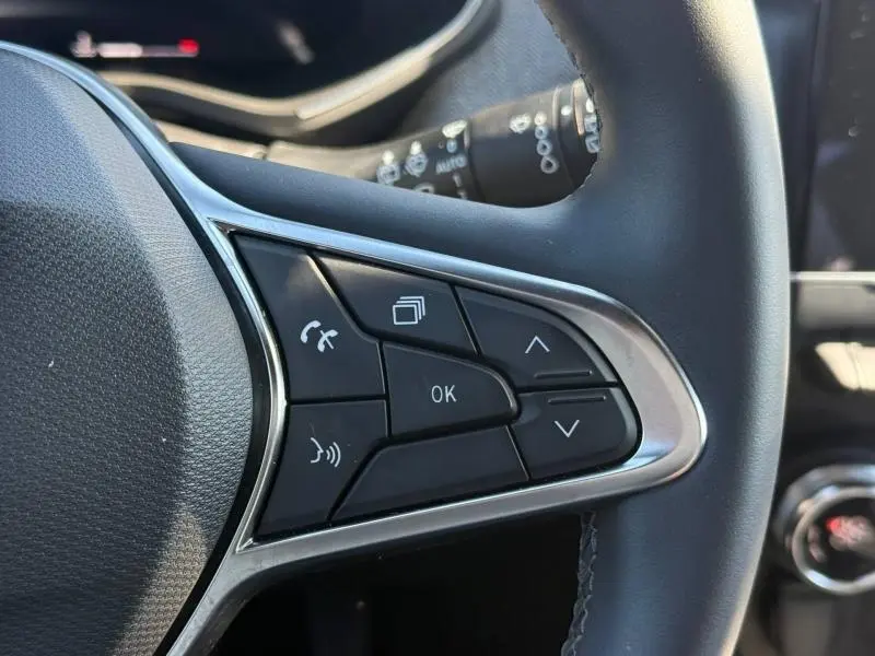 Gros plan sur les commandes multifonctions à droite du volant de la Renault Clio 2025, finition Techno, intérieur noir.