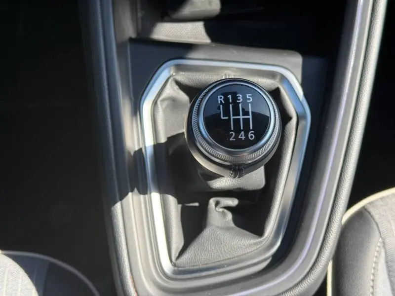 Gros plan sur le levier de vitesses manuel de la Renault Clio 2025, entouré de garniture noire avec surpiqûres grises.