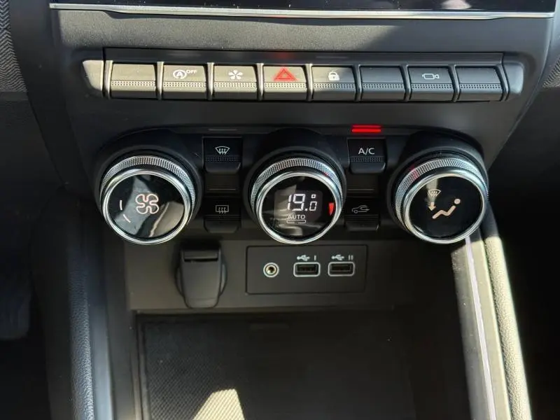 Gros plan sur les commandes de climatisation et les ports USB du tableau de bord de la Renault Clio 2025.