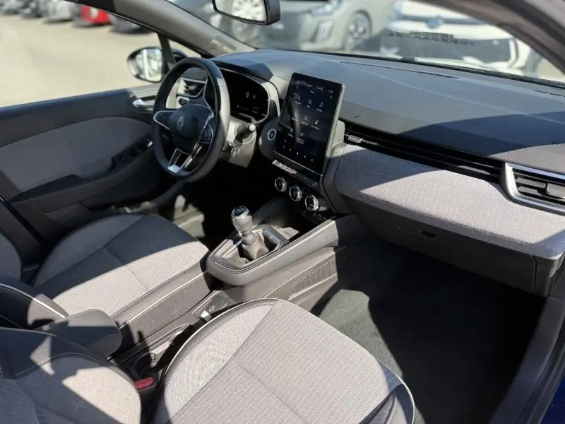 Intérieur de Renault Clio 1.0 TCe 90ch Techno 2025 vu côté conducteur, avec écran tactile vertical et sellerie grise.
