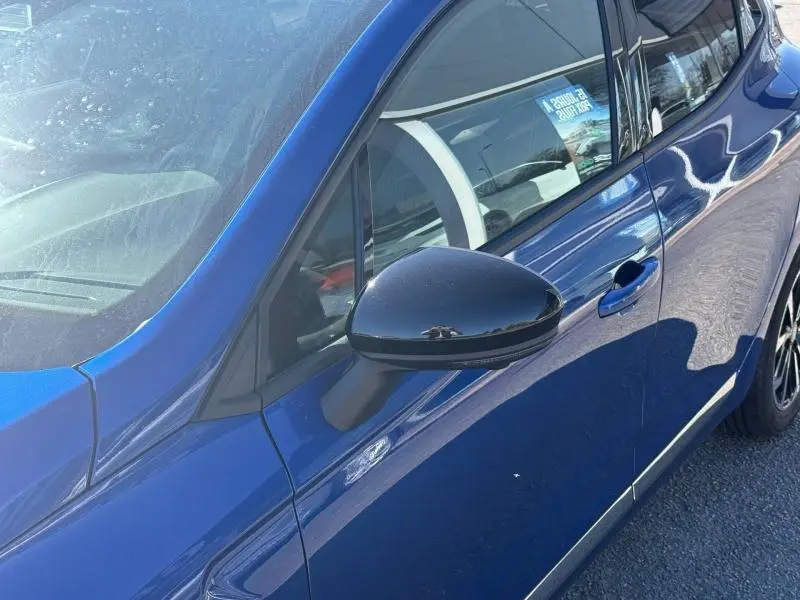 Vue rapprochée du côté gauche avant d’une Renault Clio 2025 Bleu Iron avec rétroviseur noir brillant.