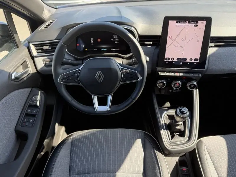 Vue intérieure centrée sur le volant et la console centrale d’une Renault Clio 2025, boîte manuelle, avec écran tactile vertical.