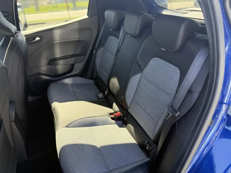 Vue intérieure arrière droite de la Renault Clio 2025 Bleu Iron, montrant les sièges tissu bi-ton avec ceinture de sécurité.
