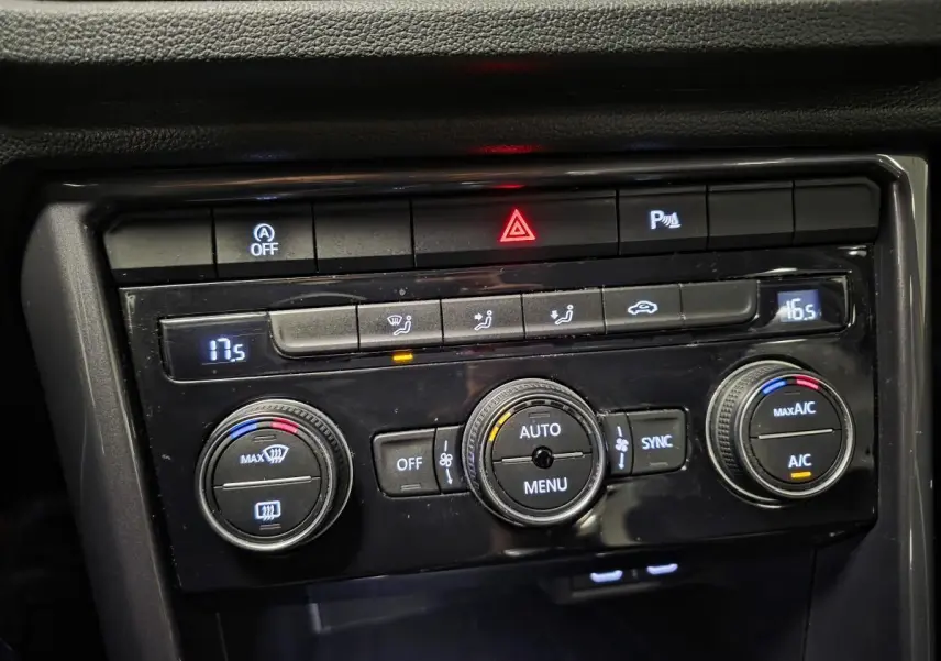 Gros plan sur la console centrale du Volkswagen T-Roc 2021, montrant les commandes de climatisation automatique bi-zone.