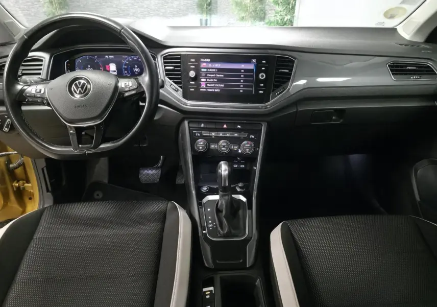 Vue intérieure avant du Volkswagen T-Roc 2.0 TDI 2021, tableau de bord noir avec écran tactile et volant multifonction.