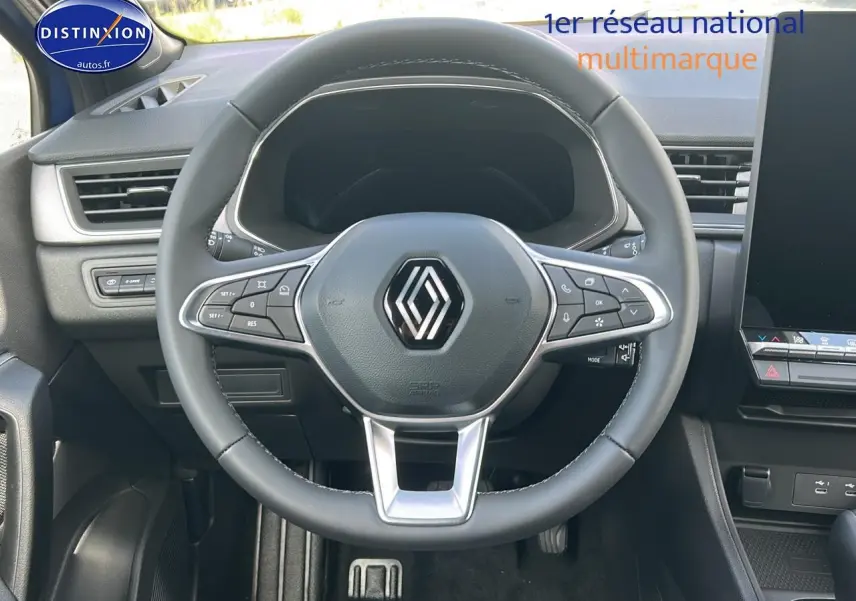 Vue intérieure centrée sur le volant multifonction noir du Renault Captur 2025, avec tableau de bord et écran tactile visibles.