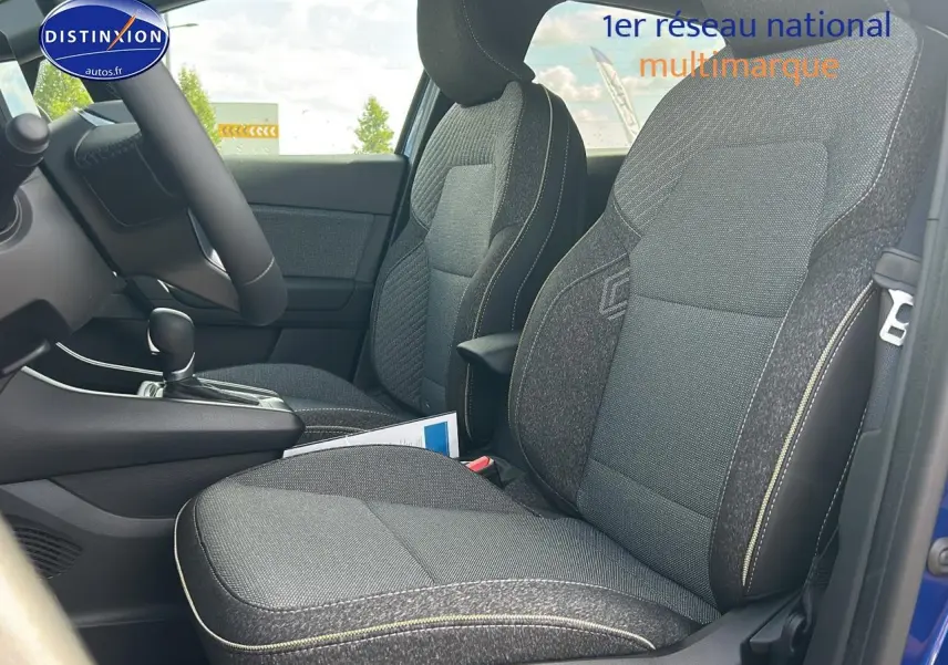 Vue intérieure côté conducteur du Renault Captur 1.6 e-tech hybride 2025 avec sièges tissu gris et surpiqûres contrastées.