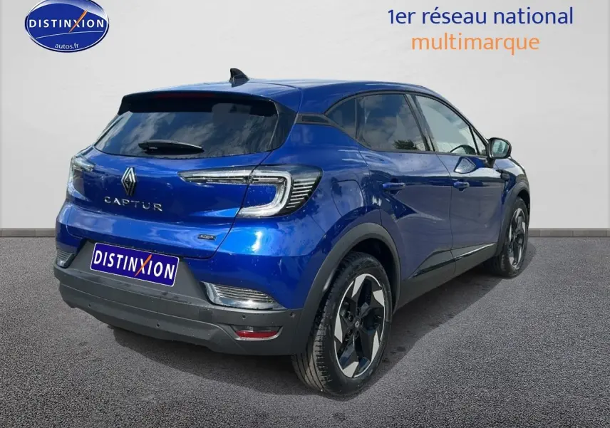 Vue 3/4 arrière droite d'un Renault Captur 2025 bleu iron avec jantes alu et vitres teintées.