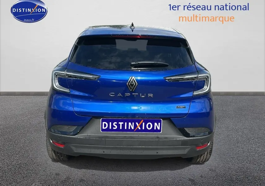 Vue arrière du Renault Captur 1.6 e-tech hybride 145 techno en bleu iron avec feux arrière LED et lunette arrière surteintée.