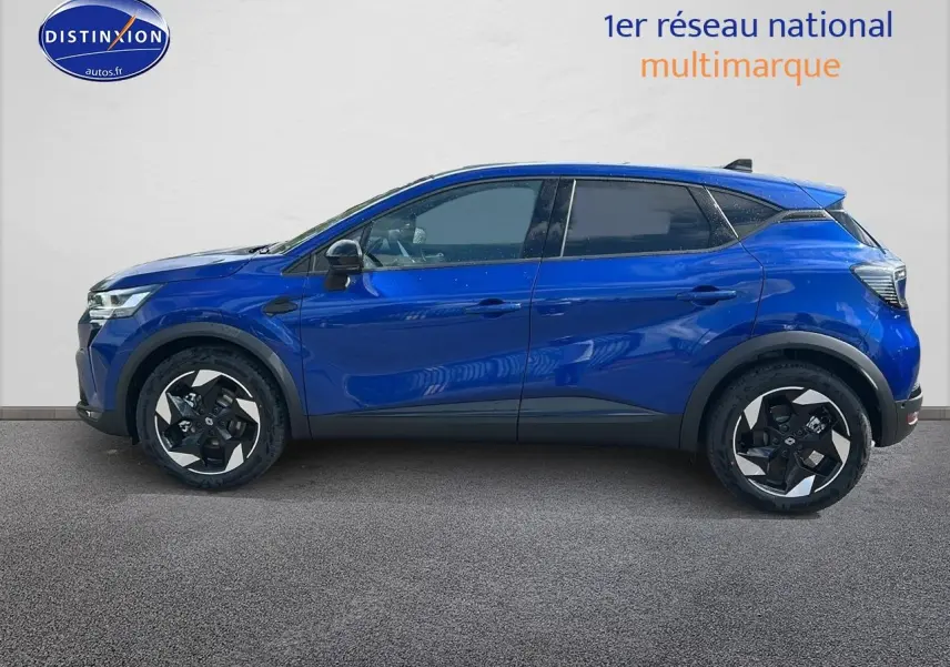 Profil latéral droit d'un Renault Captur 1.6 e-tech hybride 145 techno bleu iron avec jantes alu et vitres surteintées.