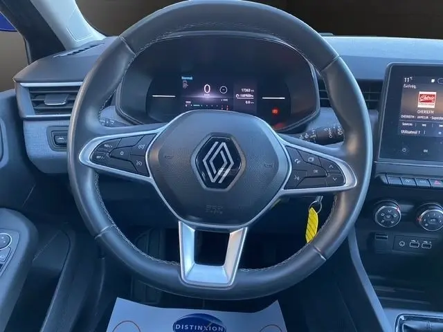 Vue rapprochée du volant en cuir synthétique de la Renault Clio Evolution TCe 90 2024 avec tableau de bord numérique et écran tactile.