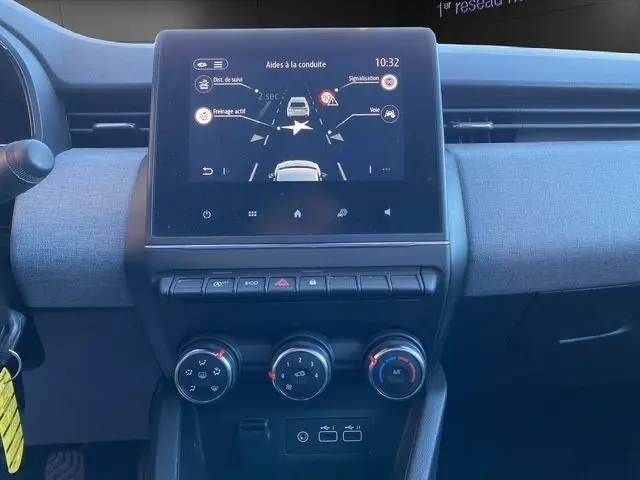 Vue frontale de l’écran tactile central et des commandes de climatisation d’une Renault Clio gris foncé Evolution TCe 90 2024.