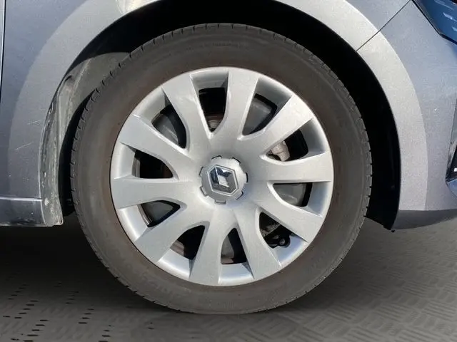 Gros plan sur la roue avant gauche d'une Renault Clio gris foncé 2024 avec jante en alliage et logo central Renault.