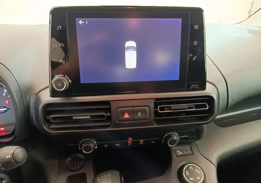 Vue rapprochée du tableau de bord du Citroën Berlingo blanc 2022, écran tactile central et commandes climatisation.