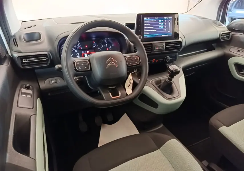 Intérieur du Citroën Berlingo 2022 vue du poste de conduite, volant multifonctions et écran tactile central visibles.