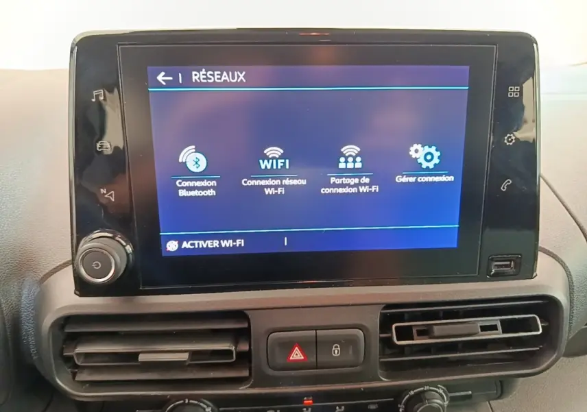 Écran tactile central du tableau de bord du Citroën Berlingo blanc, affichant les options de connexion Wi-Fi et Bluetooth.
