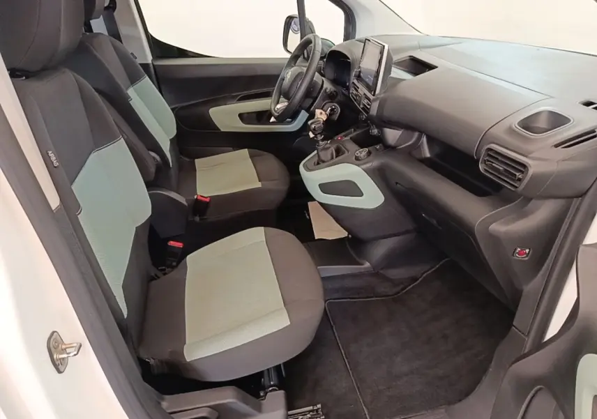 Vue intérieure côté conducteur du Citroën Berlingo blanc 2022, sièges bicolores et tableau de bord avec écran tactile.