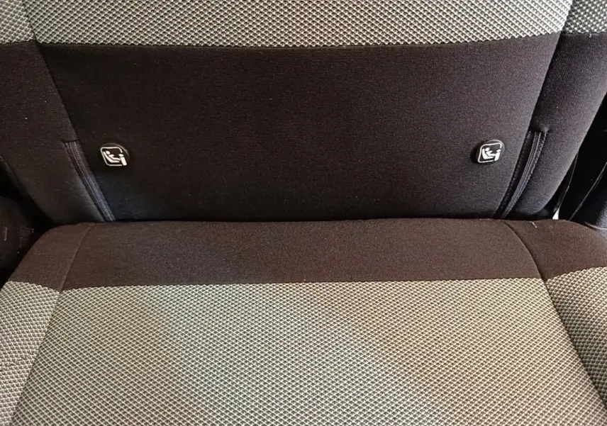 Gros plan sur la banquette arrière bi-ton gris et noir du Citroën Berlingo avec attaches Isofix visibles.