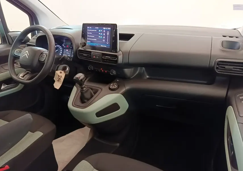 Vue intérieure avant droite du Citroën Berlingo blanc 2022, tableau de bord avec écran tactile et volant multifonctions.
