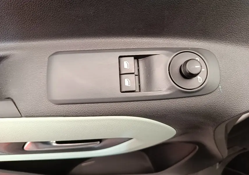 Détail des commandes de réglage des rétroviseurs et des vitres sur la porte avant gauche d’un Citroën Berlingo blanc.