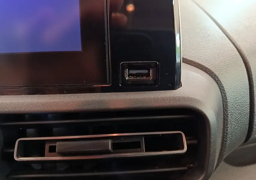 Détail de la console centrale du Citroën Berlingo blanc 2022, avec prise USB et sortie d'air rectangulaire.