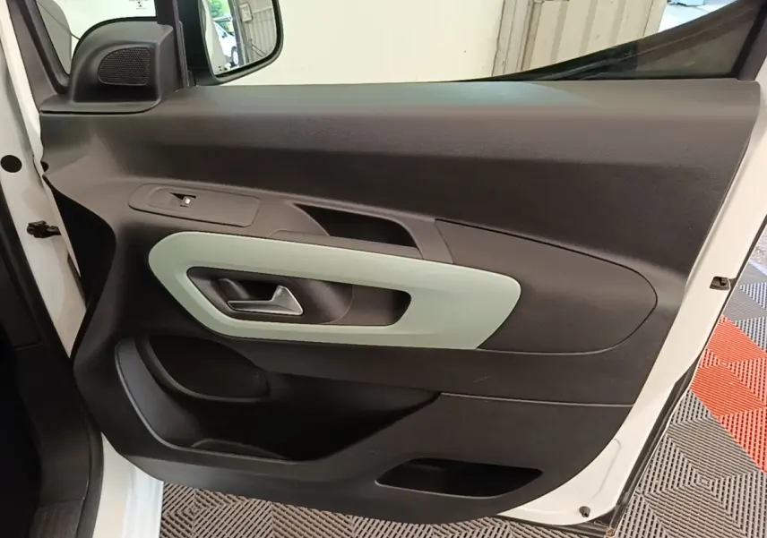 Vue rapprochée de la porte avant gauche blanche du Citroën Berlingo 2022 avec insert décoratif gris clair.