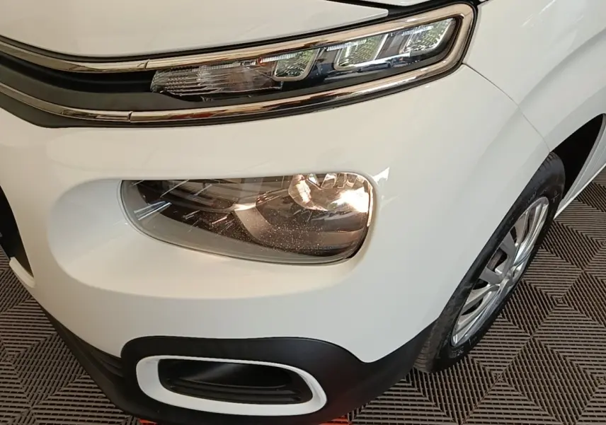 Gros plan sur l’avant droit blanc du Citroën Berlingo 2022, mettant en valeur les phares LED et antibrouillards.