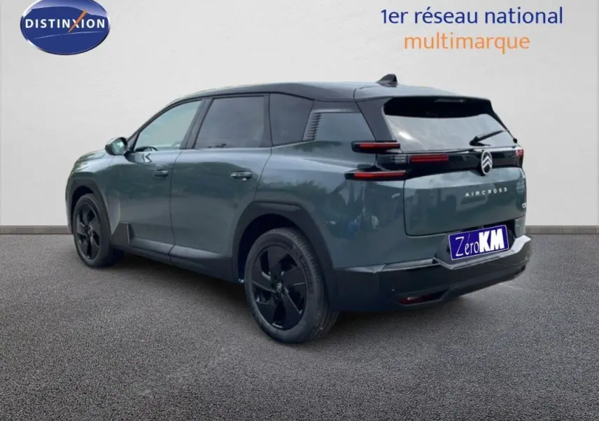 Vue 3/4 arrière droite d'un Citroën C5 Aircross Hybrid 145 vert Astoria avec toit noir et jantes noires.