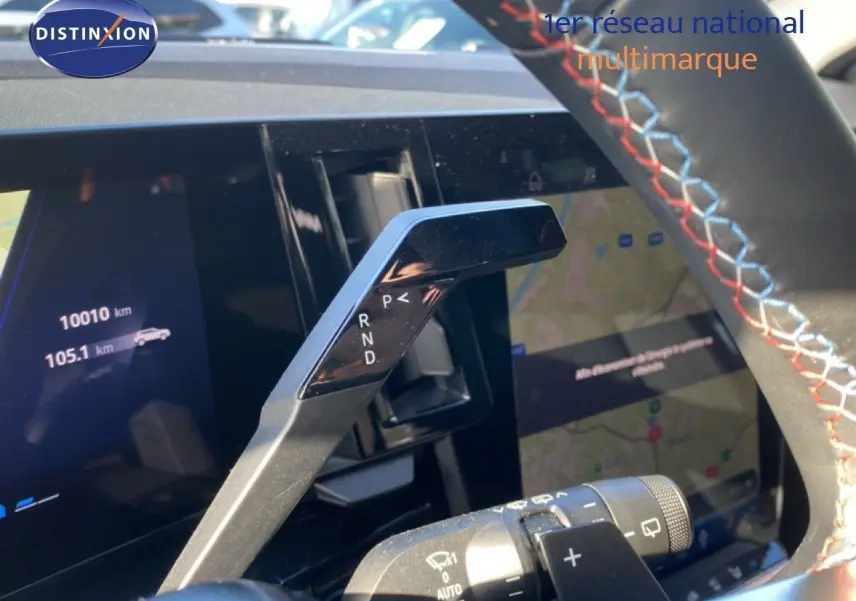 Gros plan sur la commande de boîte automatique à palettes dans l'habitacle du Renault Austral blanc nacré 2024.
