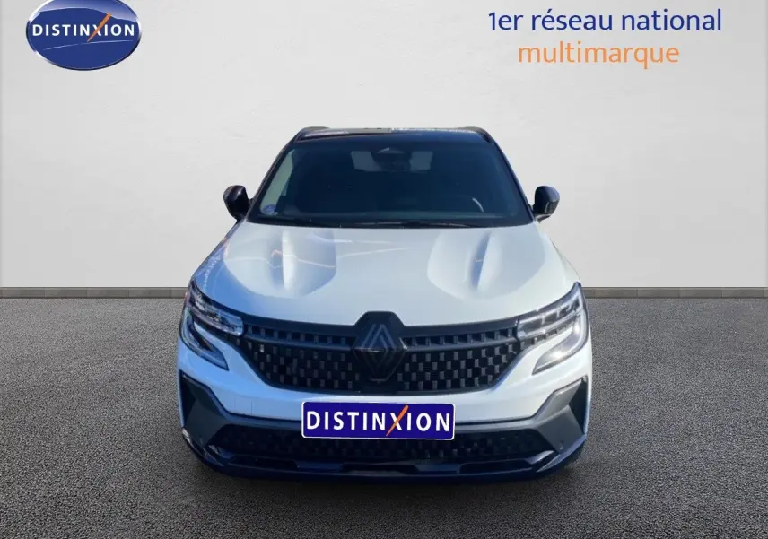 Vue frontale d'un Renault Austral blanc nacré avec toit noir, mettant en valeur sa calandre et ses phares LED modernes.