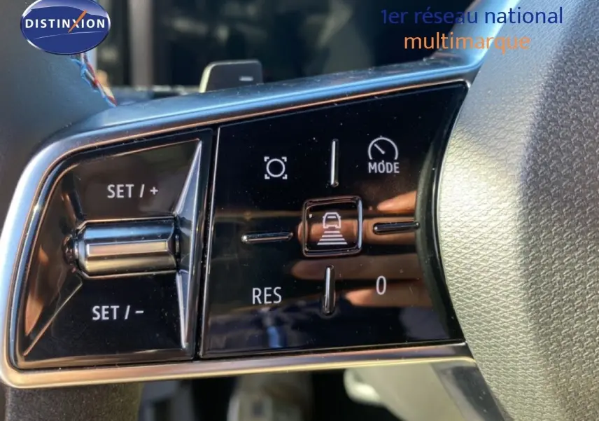 Gros plan sur les commandes de régulateur de vitesse au volant du Renault Austral blanc nacré 2024.