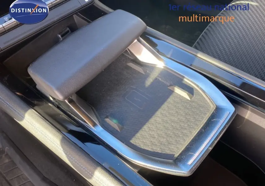 Plateau de recharge sans fil et accoudoir central dans l'habitacle noir du Renault Austral E-Tech 2024.